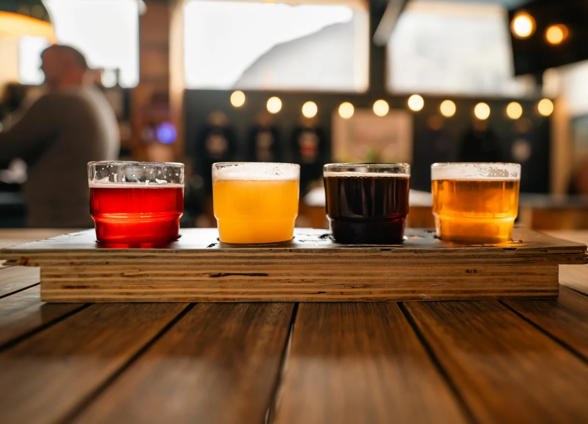 Plateau de verres de bière posé sur une table en bois, illustration de l’actu bière de la semaine