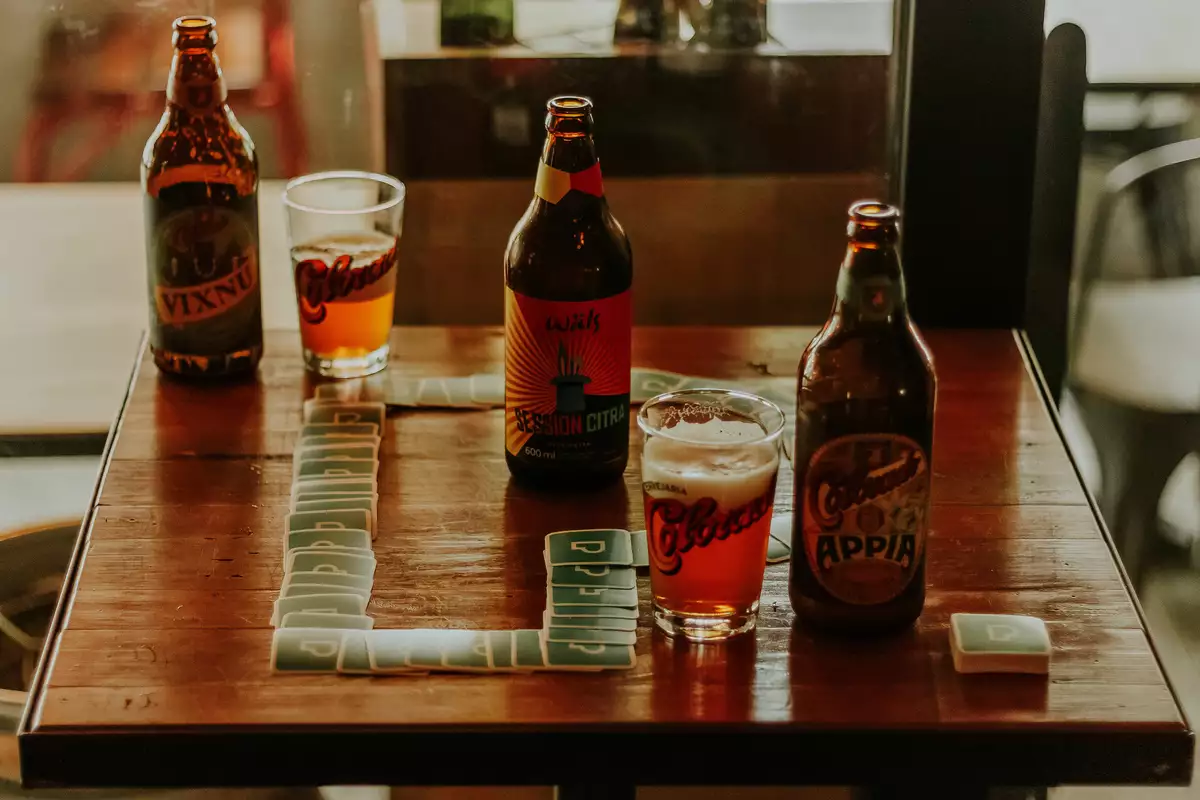 Bouteilles de bière brune posées sur une table en bois, dans l’esprit d’une dégustation de Chimay Bleue
