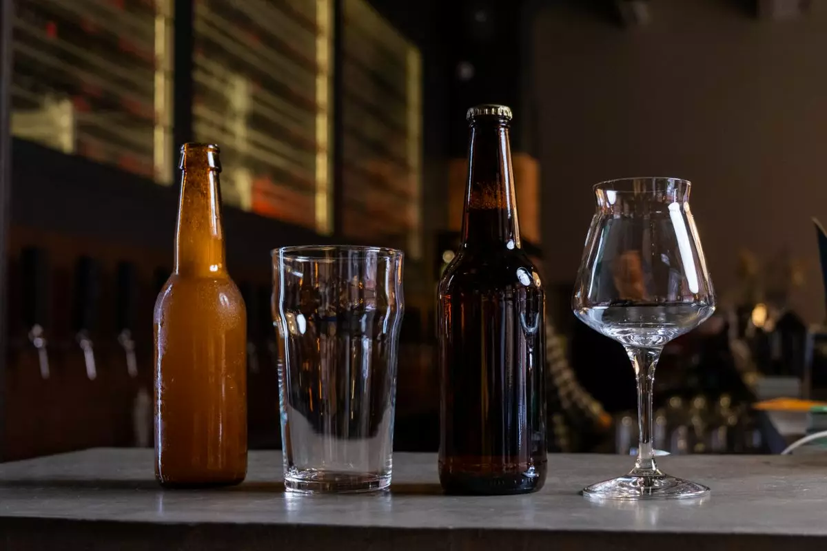 Bouteilles de bière artisanale alignées sur une table, comme celles brassées par la Brasserie de Serre-Ponçon